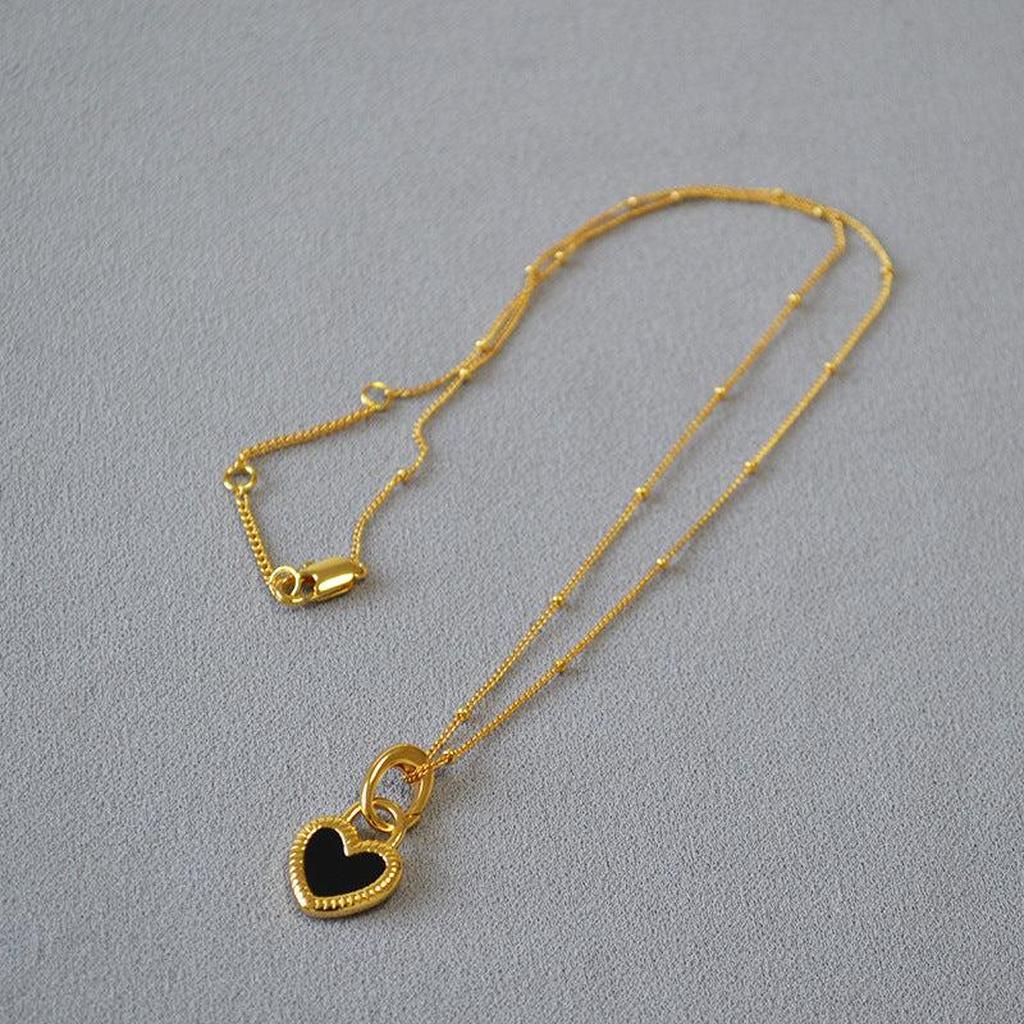 Halskette mit schwarz-weißem Herzanhänger in Gold