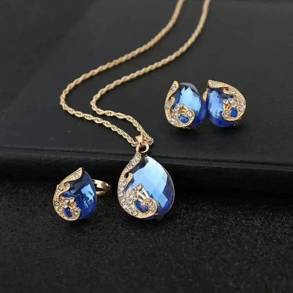 Parure dorée — Collier et boucles d’oreilles au cristal bleu
